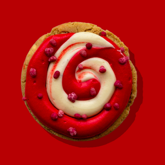 North Pole Maxi cookie with white chocolate base, raspberry and vanilla cream cheese frosting, and raspberry candy sprinkle.