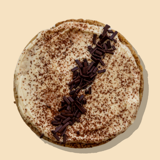 Tiramisu Maxi cookie with chocolate chip base, coffee-infused frosting, cocoa powder, and chocolate flakes.