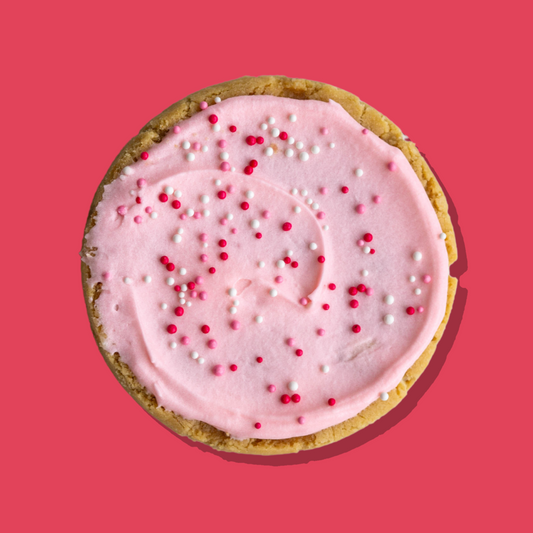 Hot Girl Christmas cookie with pink marshmallow cream cheese frosting and festive sprinkles.