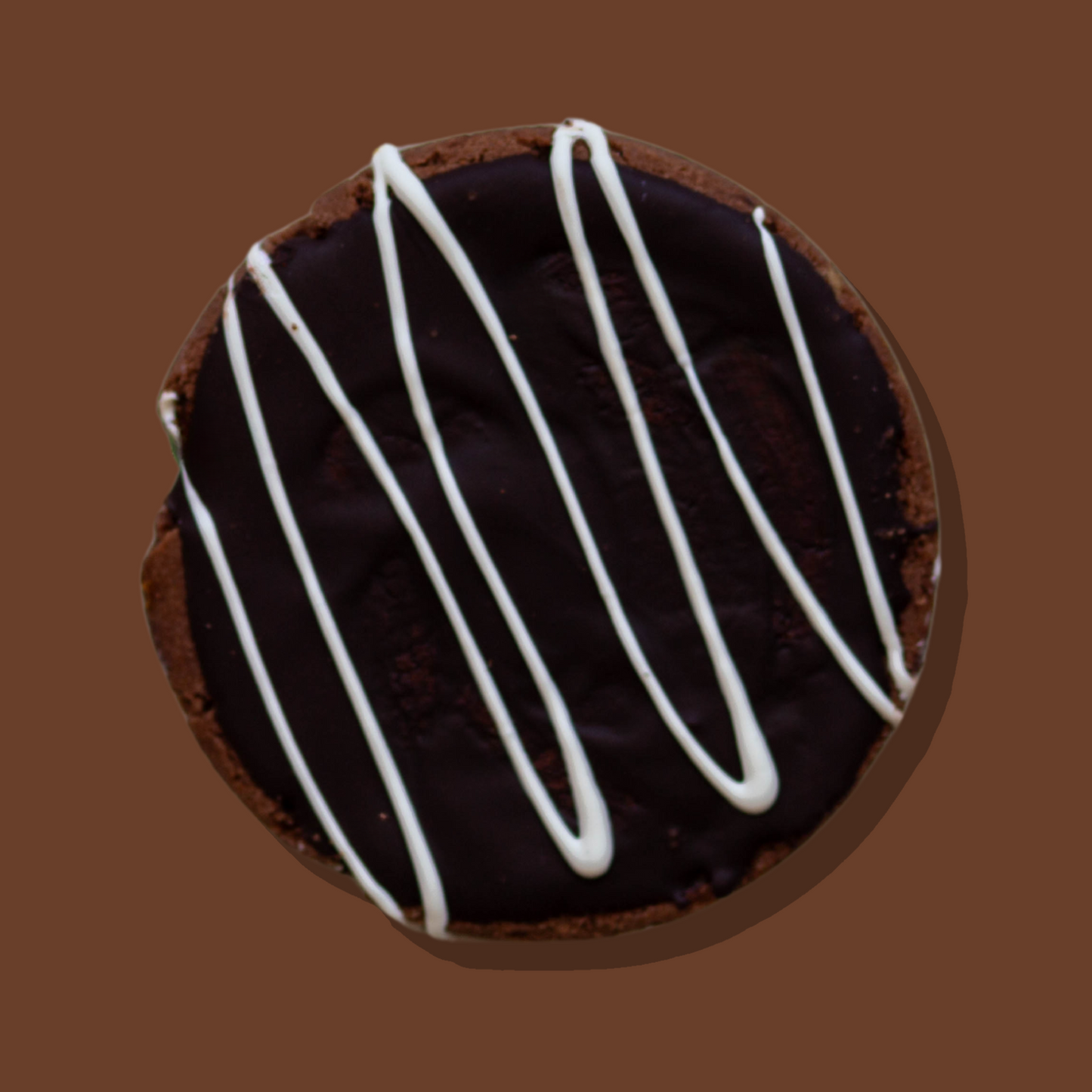 Choc Mudcake Maxi Cookie with chocolate ganache and white chocolate drizzle.