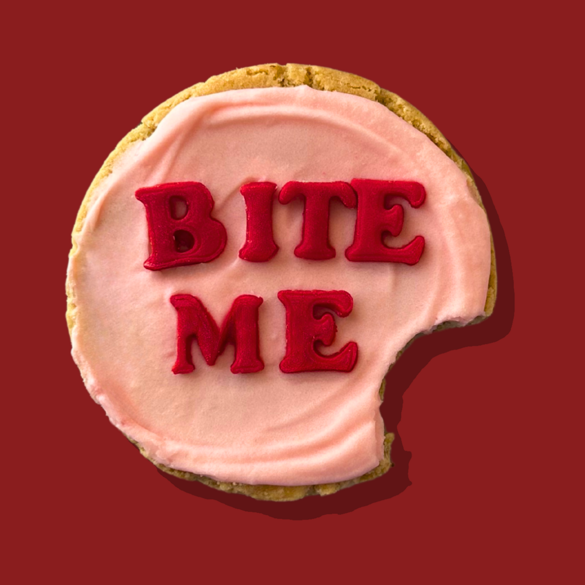 Anti-Cupid Maxi cookie with pink frosting and "Bite Me" text.