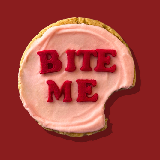 Anti-Cupid Maxi cookie with pink frosting and "Bite Me" text.
