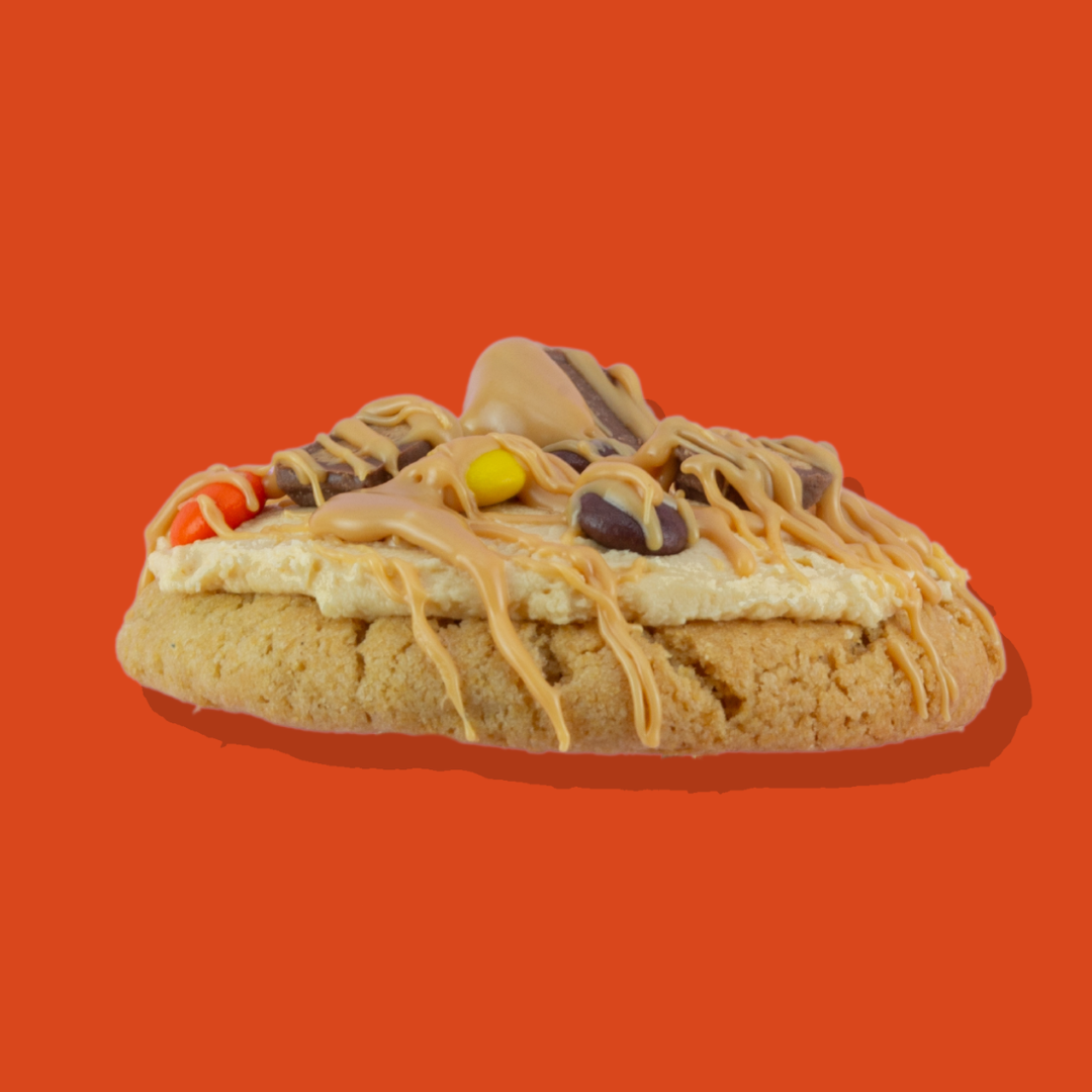 Reese's Pieces Maxi cookie with milk chocolate, peanut butter chips, and buttercream topping.