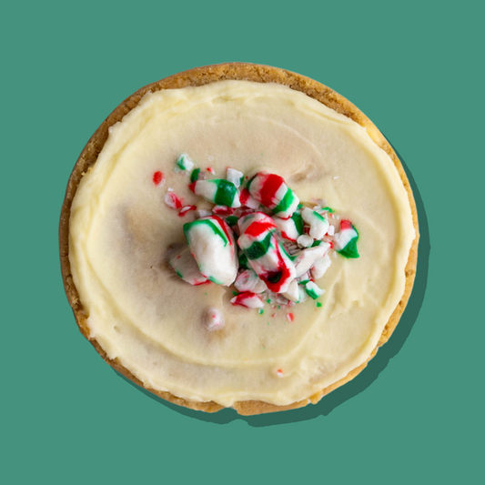 Peppermint Kiss Maxi cookie with white chocolate base, peppermint cream cheese frosting, topped with crushed peppermint candy.