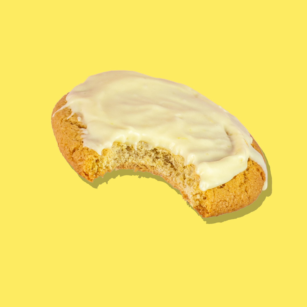 Lemon cheesecake cookie with creamy frosting and a bite taken out.